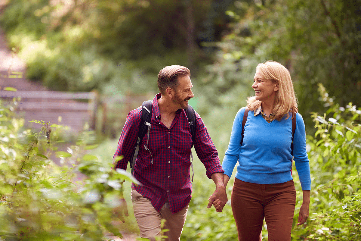 transition from active employment couple hiking in the woods after transitioning to retirement